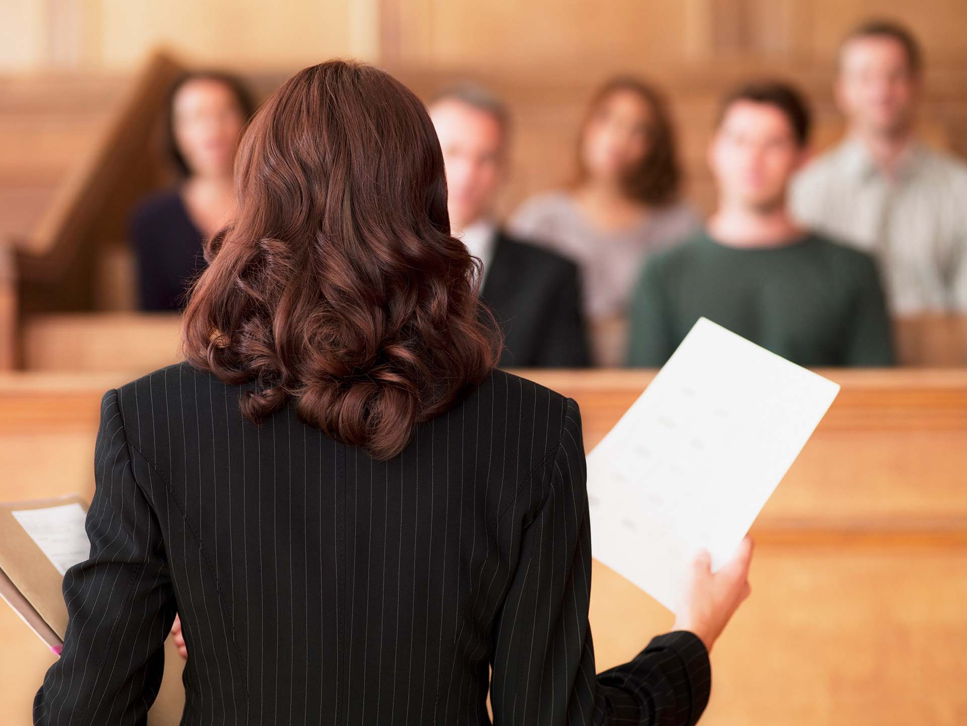 Lawyer Holding Document And Speaking To Jury In Courtroom Lawyer Holding Document And Speaking To Jury In Courtroom