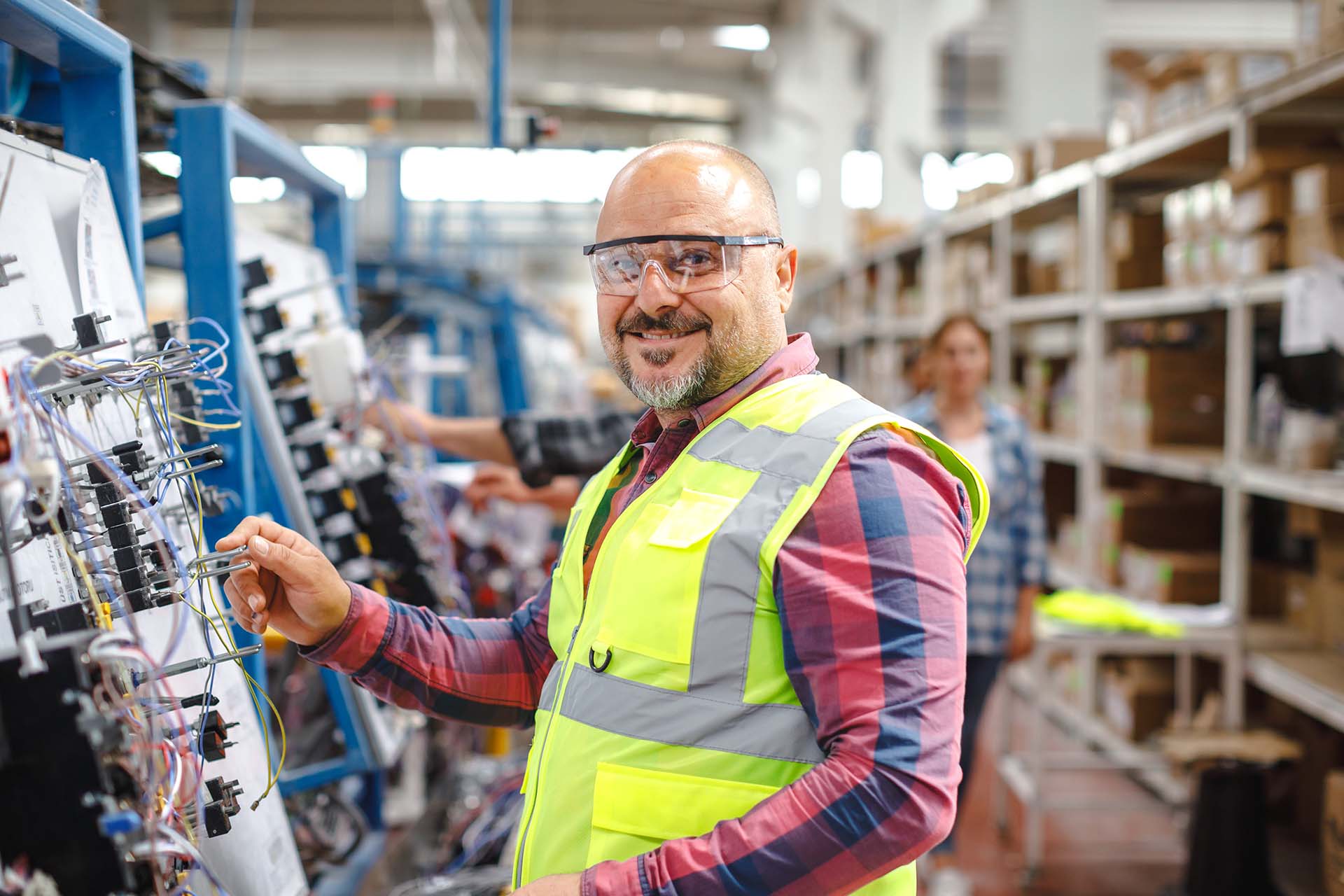 Joyful Work: Smiling Mature Manual Worker Man At Manufacturing Factory Discover the joy and contentment on the face of a mature manual worker as he carries out his duties at a manufacturing factory. This captivating portrait captures his genuine smile, reflecting his satisfaction and fulfillment in his work. Witness the dedication and experience that shines through his eyes in this vibrant image."