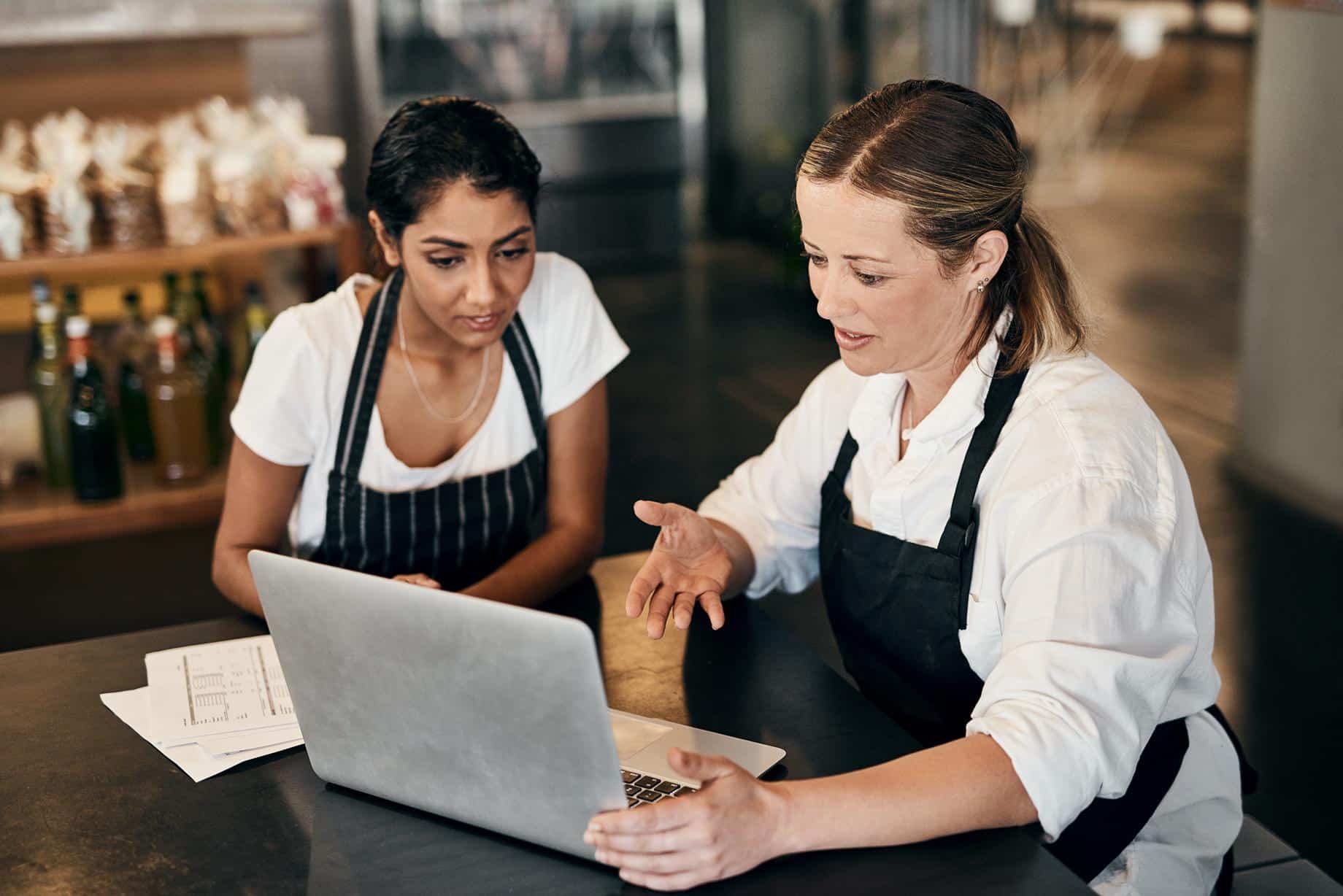 The kind of teamwork a small business thrives on. two women using a laptop together while working in a cafe