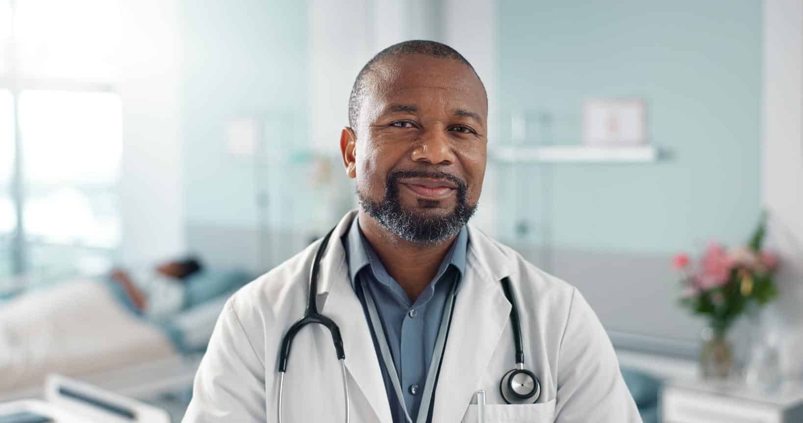 Healthcare, doctor and black man with arms crossed at hospital with smile for support, service and wellness. Medicine, professional and African expert with happiness and pride for career or surgery.