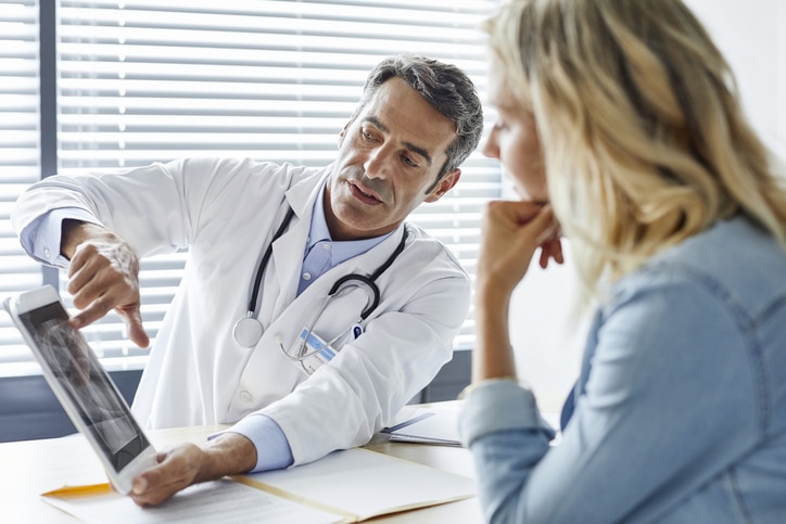 Doctor shows digital tablet to woman