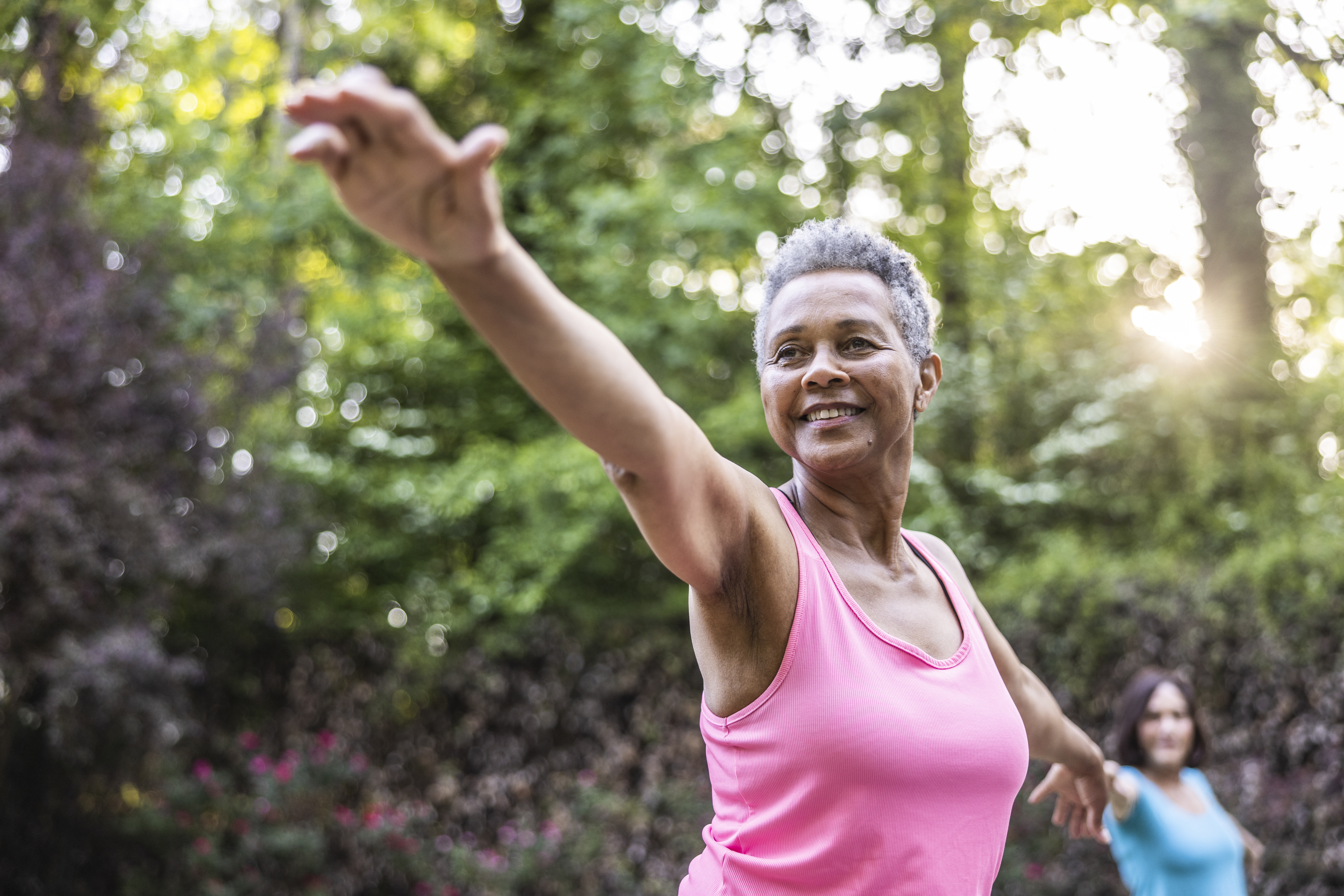 Senior women taking a yoga class in beautiful garden