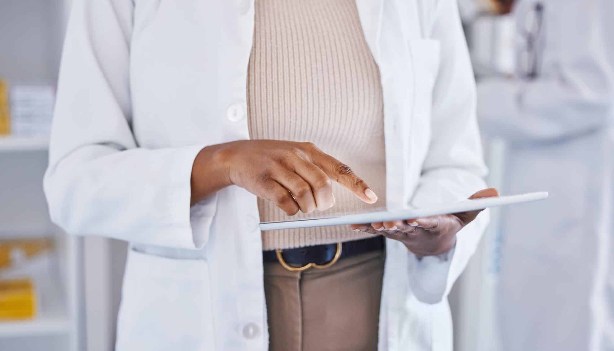 Doctor, Woman And Hands On Tablet For Healthcare, Telehealth Or Research At The Pharmacy. Hand Of Female Medical Professional In Data Analysis Or Health Insurance Holding Technology At The Clinic Doctor, woman and hands on tablet for healthcare, Telehealth or research at the pharmacy. Hand of female medical professional in data analysis or health insurance holding technology at the clinic.